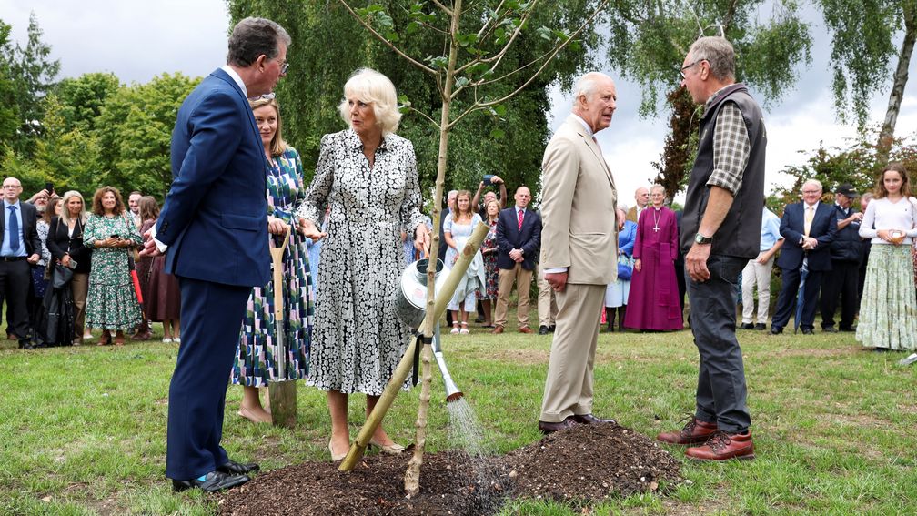 The King and Queen plant a tree during their visit to the National Stud