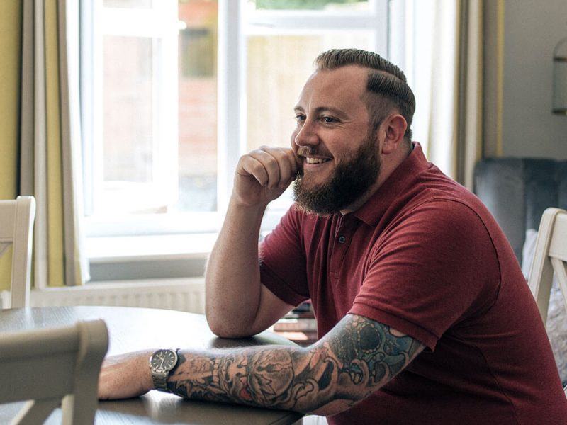 Dean sitting at a table smiling