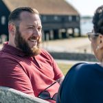 Dean chatting on a bench