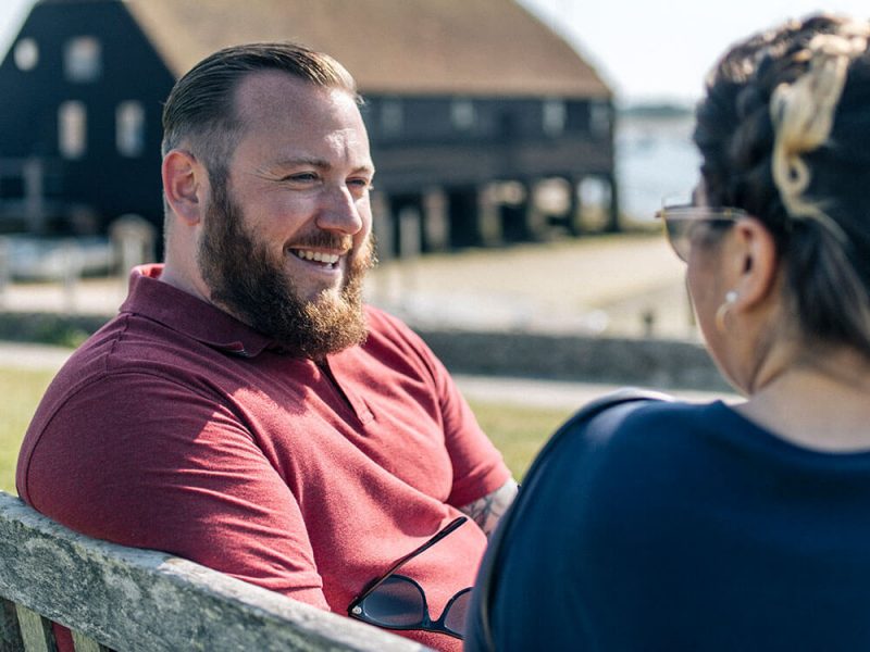Dean chatting on a bench