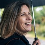 Lady smiling while holding an umbrella