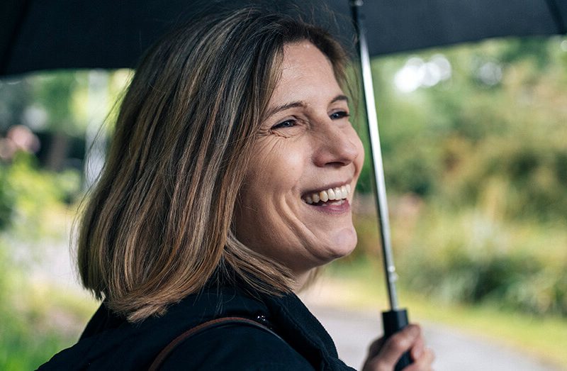 Lady smiling while holding an umbrella