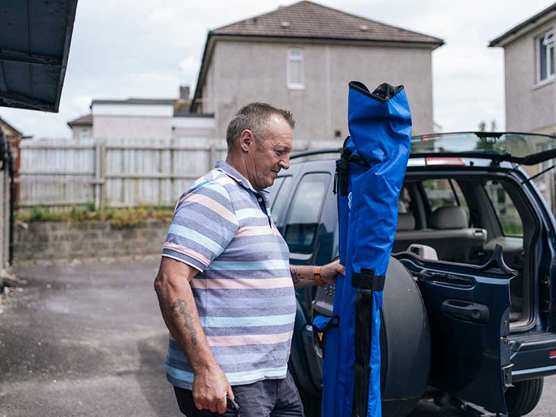 Kevin putting fishing rods in the car