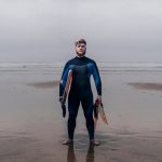 Ben on the beach holding his bodyboard