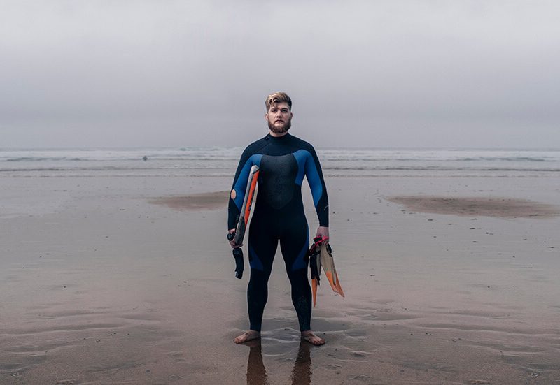 Ben on the beach holding his bodyboard