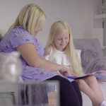 Suzie on sofa reading with daughter