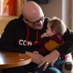 Martin holding daughter at table