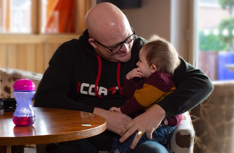 Martin holding daughter at table