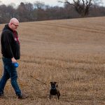 Martin walking dog in field