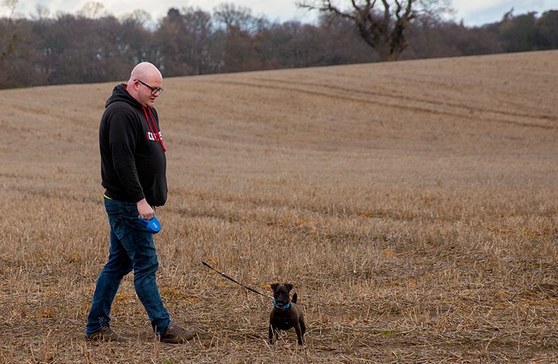 Martin walking dog in field