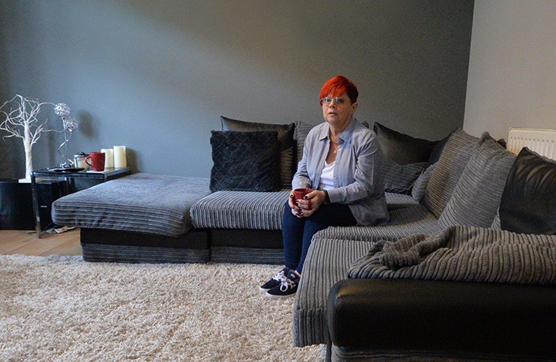 Sue sitting on her sofa