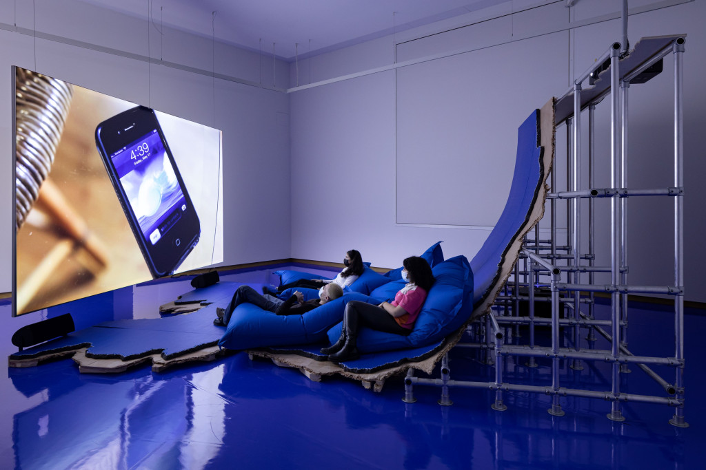 Zaalbeeld, mensen kijken naar een scherm. 