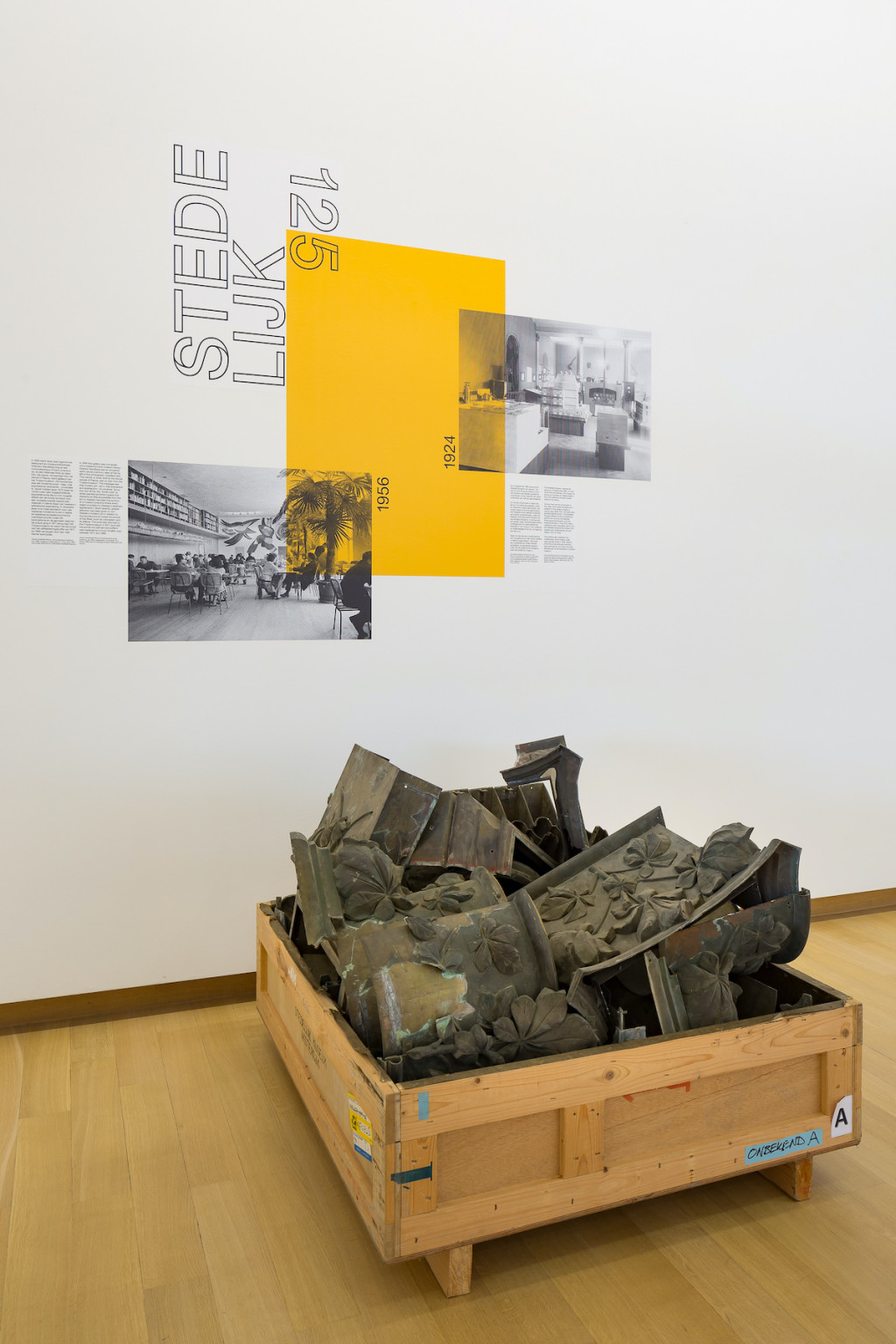 Voormalige architectuurdecoratie van zaal 0.1, met kapiteel- en basement-ornamenten in een koperlegering aan zuilen en pilasters en bruinrood gekleurde wanden, architect: Abraham Willem Weissman, 1895. Foto: 1924 (Brandweer-tentoonstelling).