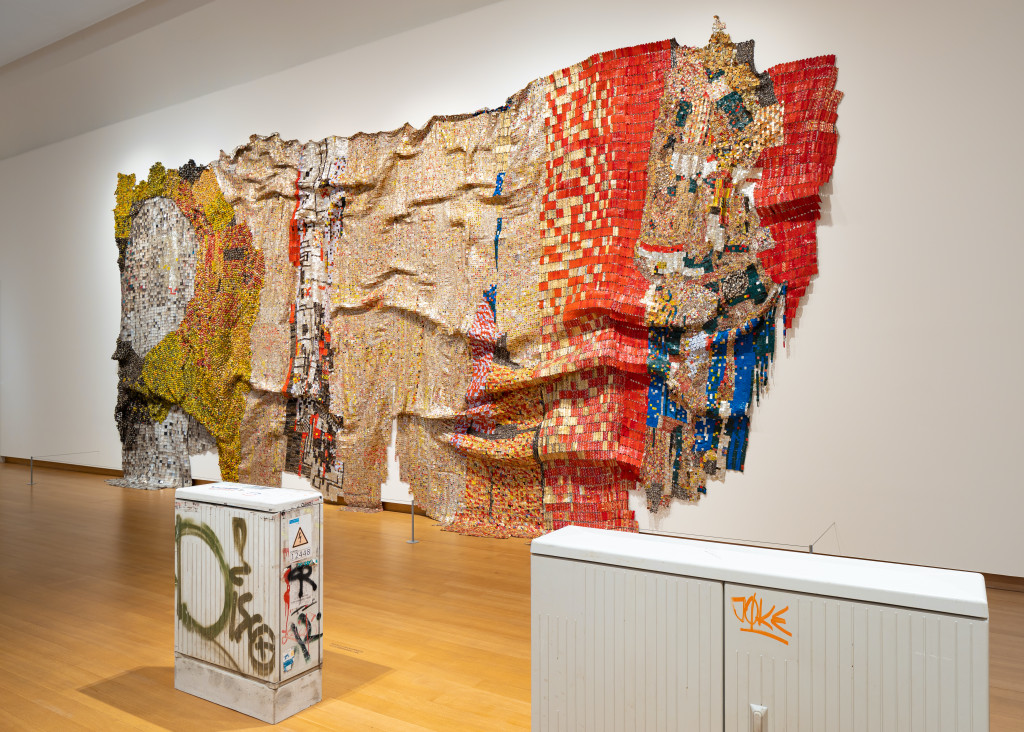 El Anatsui, In the World But Don't Know the World, 2009. Sigg Collection (achter) en Klara Lidén, Disco (links) en Joke (rechts), 2020. Met dank aan Sadie Coles HQ, Londen. Foto Peter Tijhuis