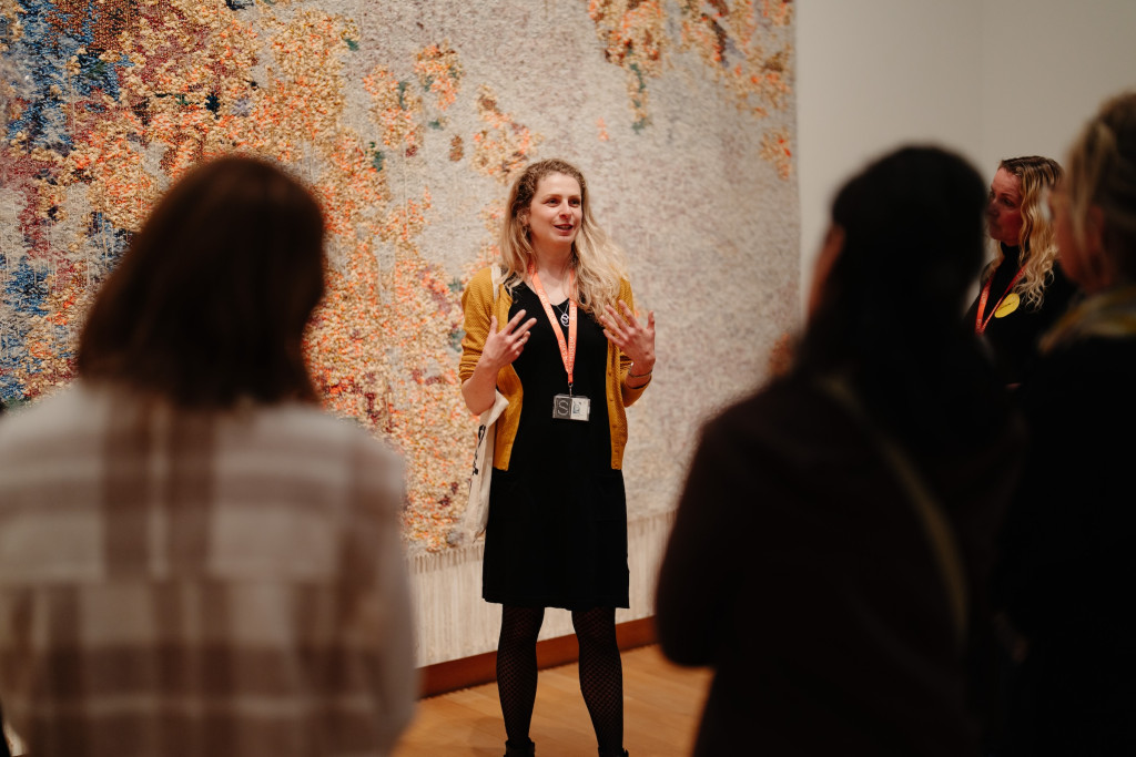 foto van rondleider en mensen voor het kunstwerk Nama Stap