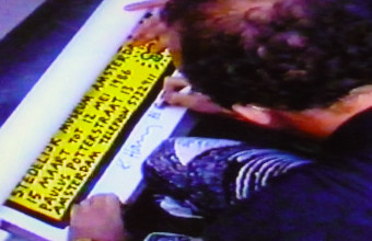 Keith Haring signing a poster after his lecture and tv-interview, Stedelijk Museum, Amsterdam, 15 March 1986; local TV Photo still: Chris Reinewald.