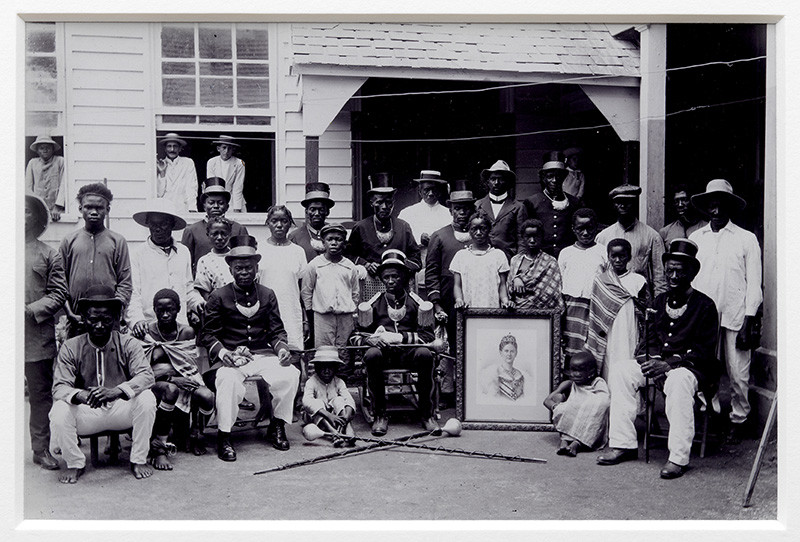 Augusta Curiel, Paramaribo, granman Amakti met zijn kapiteins en het portret van koningin Wilhelmina, ca. 1923. Collectie Stichting Nationaal Museum van Wereldculturen. Coll.nr. [TM-60006213]