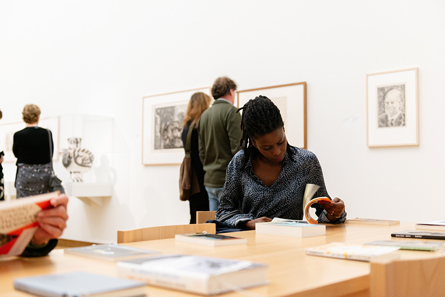 Visitors to the exhibition at the reading table with publications by Aimé Césaire, Albert Memmi, David Diop, Fouad Laroui, Frederick Brown and Jan and Leo Lucassen, among others. Photo: LNDW Studio.