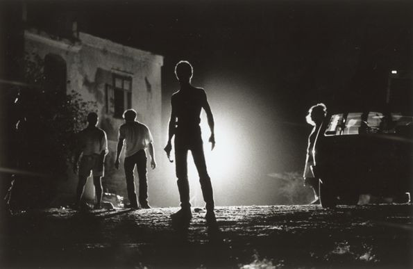 shadow of a man with a car in the background