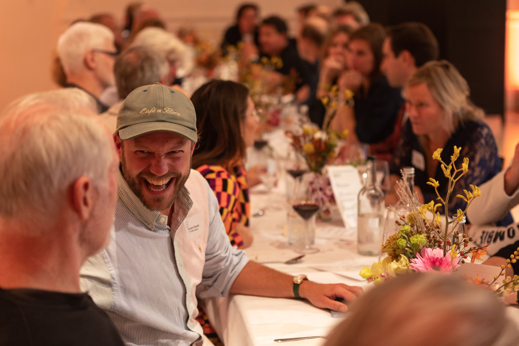lachende mensen aan een tafel tijdens clubdiner