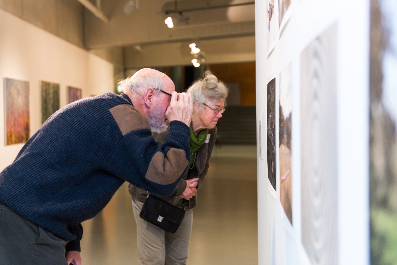 Twee bezoekers bekijken een kunstwerk van dichtbij