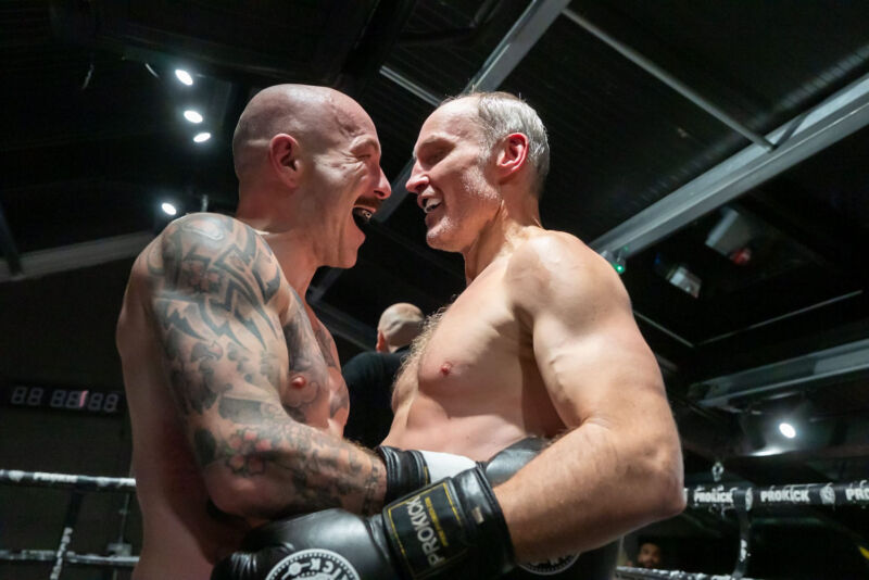 Celebrating the end of their trilogy match - When the judges rendered their decision, it was the red corner — Ian Young — who edged the victory. The crowd erupted for both men.
