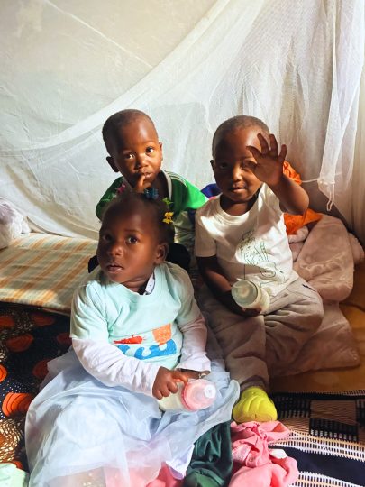 Triplets smiling and waving