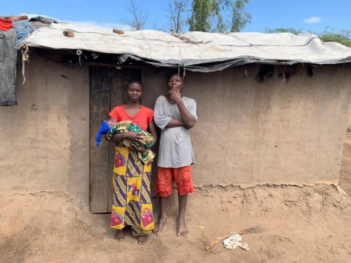 Uncle and aunt with baby niece outside house