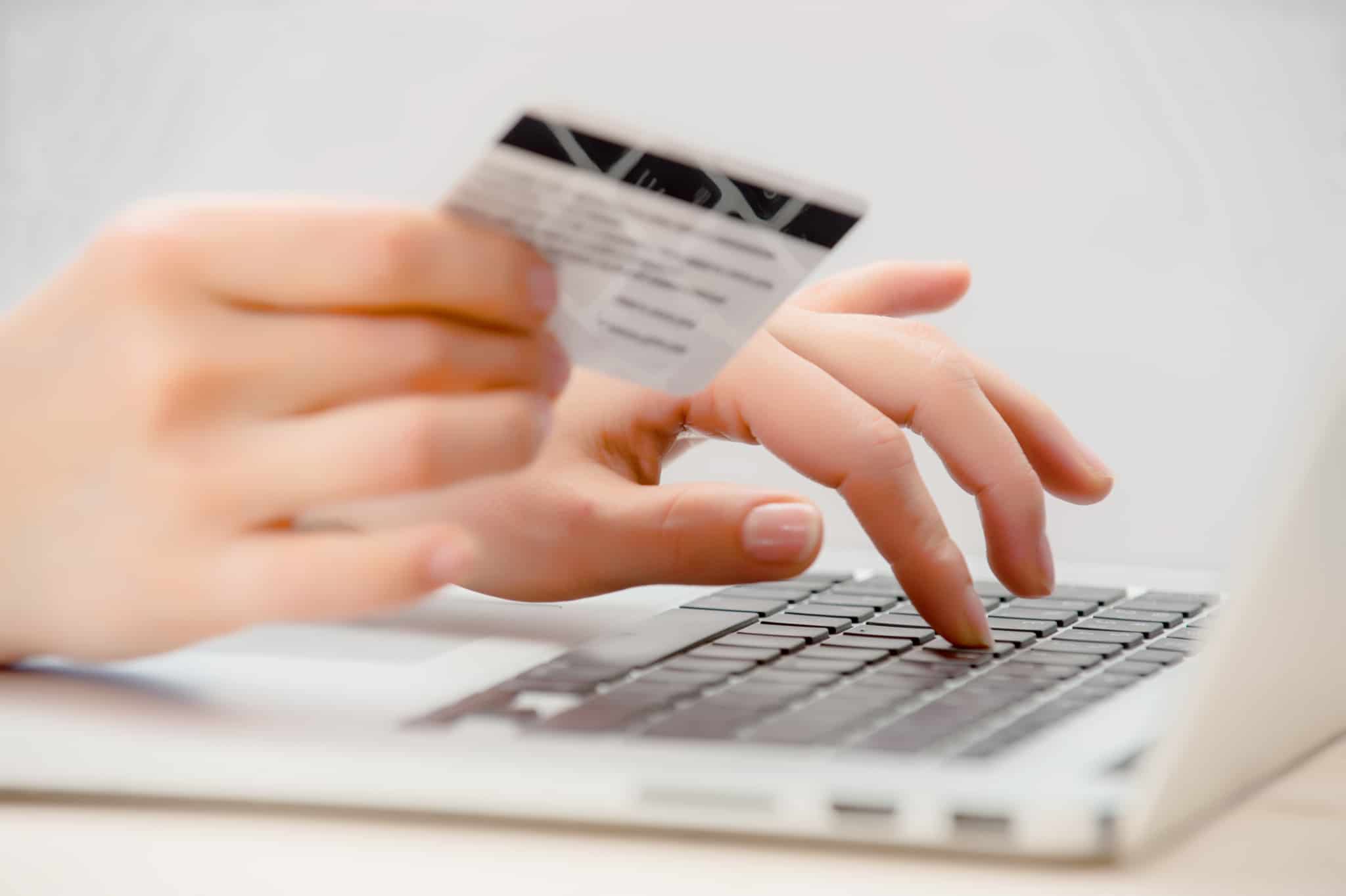 pessoa a fazer compras online a segurar cartão