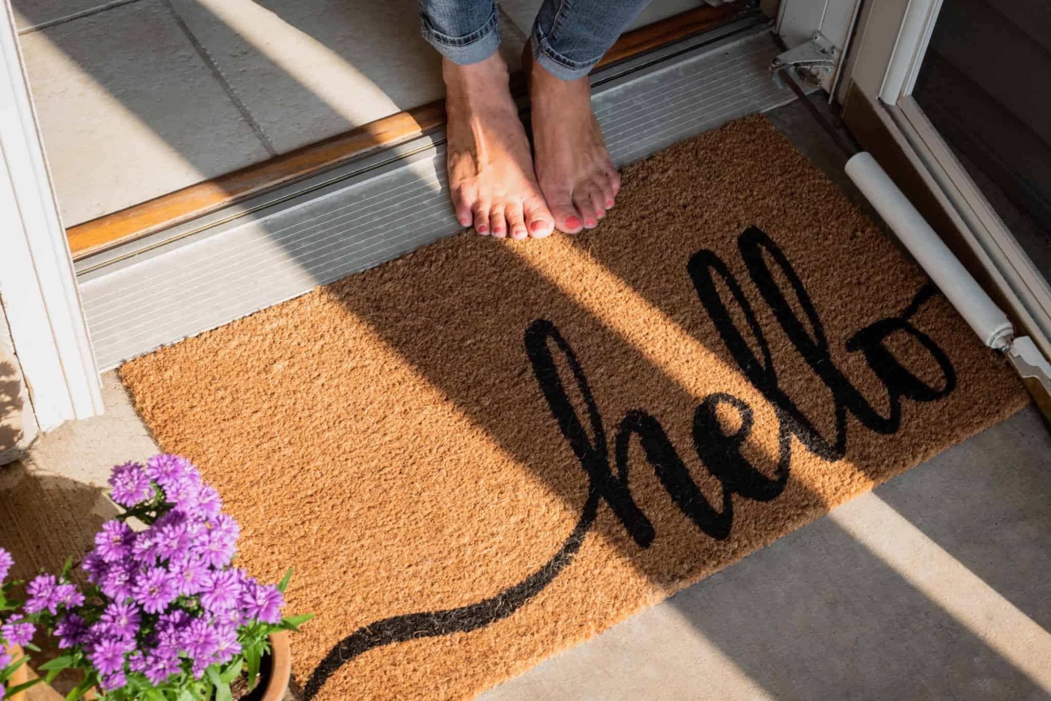 tapete de entrada de casa com a palavra hello em preto