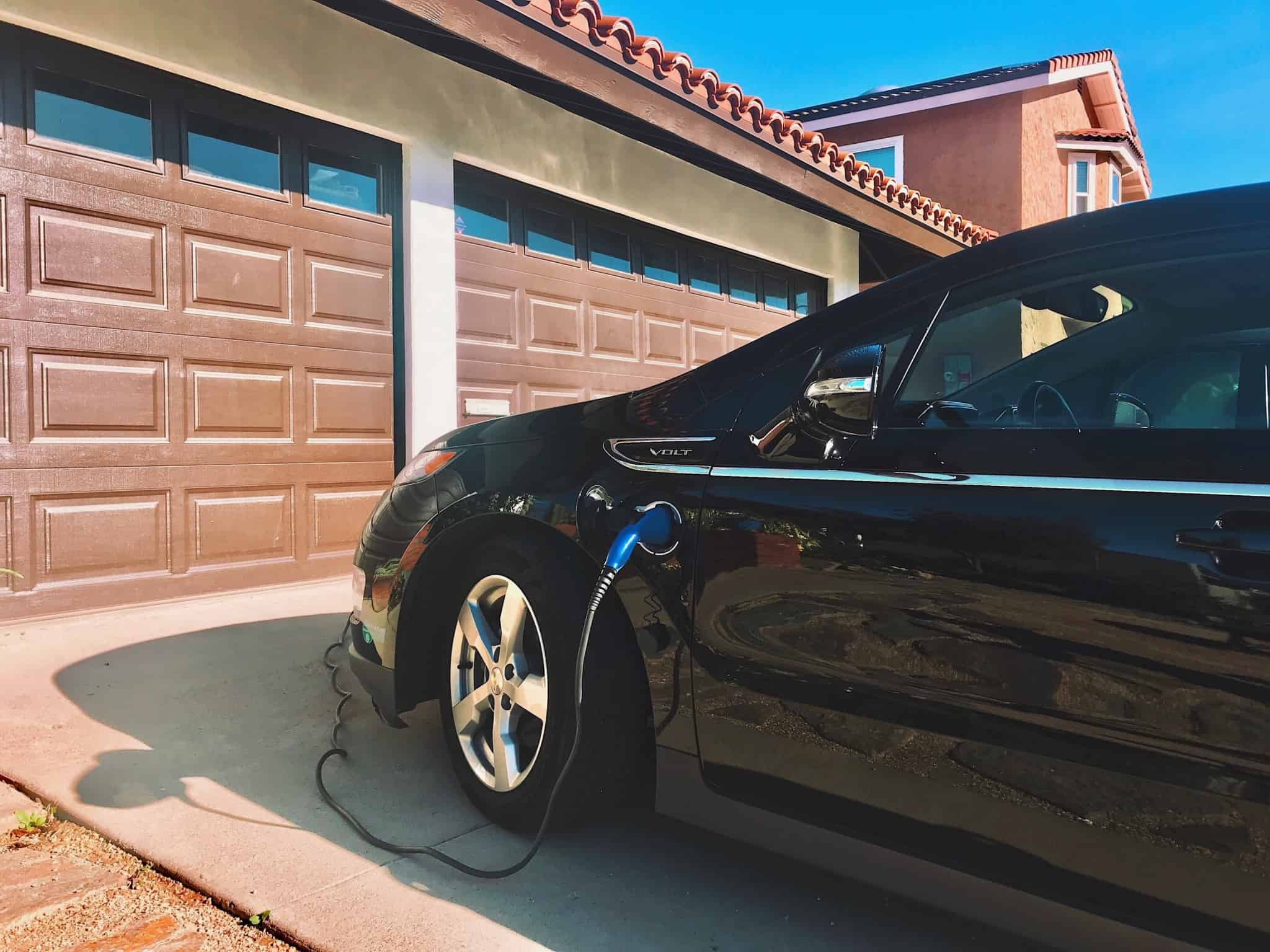 carro eléctrico a ser carregado à porta da garagem