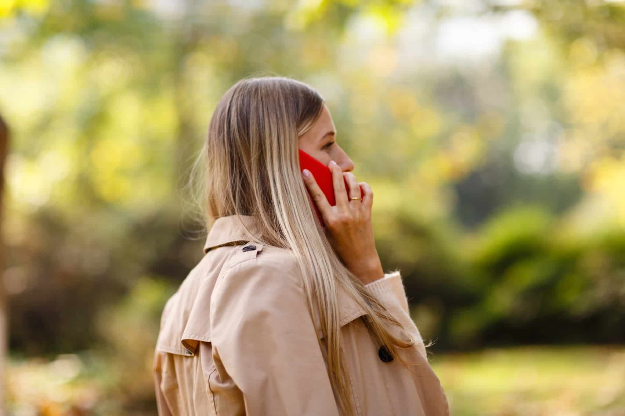rapariga loira no parque a falar ao telefone