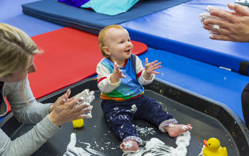 Young child playing with white paint
