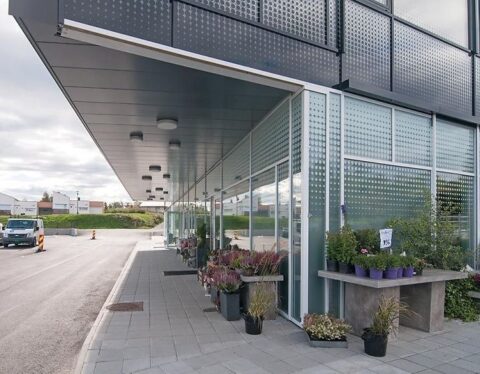 Glasshjørne på Storebøportalen i Austevoll sett fra gateplan med blomster og planter utstilt i front.