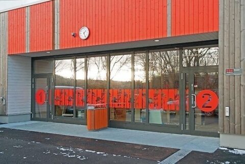 Inngangsparti på Søreide Skole i Bergen med store Schüco glassfelt og detaljer i rødt.