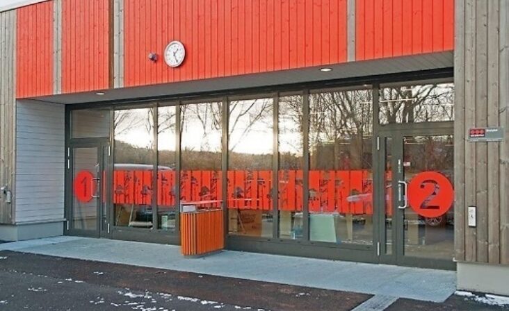 Inngangsparti på Søreide Skole i Bergen med store Schüco glassfelt og detaljer i rødt.