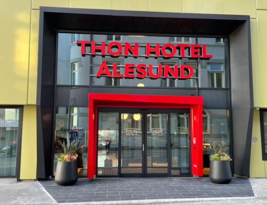 Inngangsparti til Thon Hotel Ålesund med innbydende Schüco glassfasade og røde ramme rundt inngangsdøren.