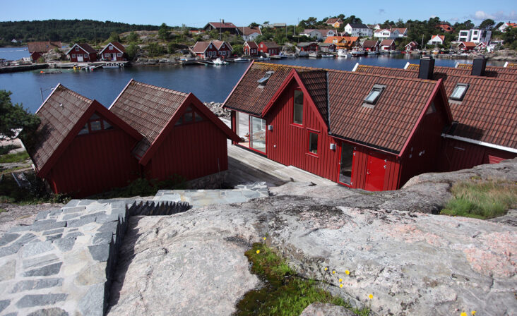 Den røde sjøbu på Langenes med Schüco skyvedør, sett fra trappen ned til bryggen med utsikt over Søvika.