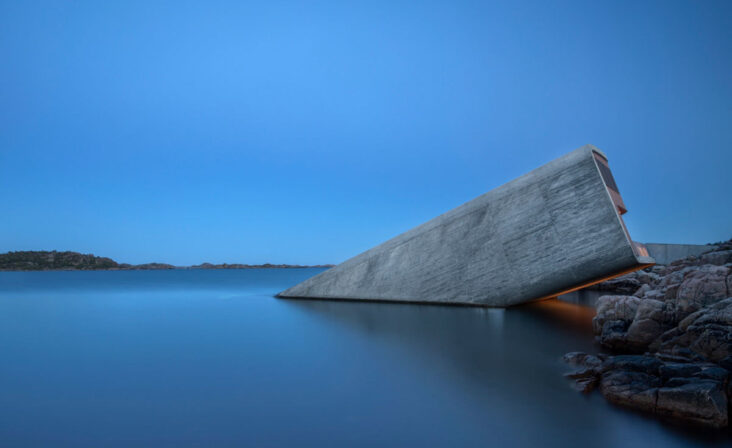 Under Restaurant i Lindesnes om kvelden som forsvinner under den glatte vannflaten, sett fra siden.