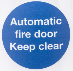 Znak BHP, tekst: "Automatic Fire Door Keep Clear, Poliester winylowy, kolor: Niebieski, biały BS EN ISO 7010 Znak