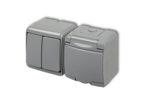 JUNIOR IP54 Wyłącznik podwójny świecznikowy z gniazdem pojedynczym z uziemieniem (klapka popielata: przesłony torów prądowych) p