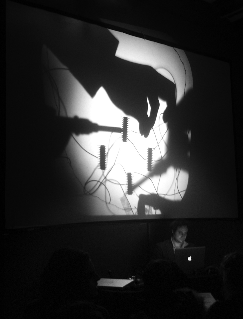 Live soldering performance by Loud Objects, showing overhead projection of work surface