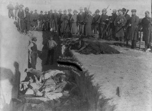 U.S. soldiers burying the Indian dead in a mass grave after the Battle of Wounded Knee