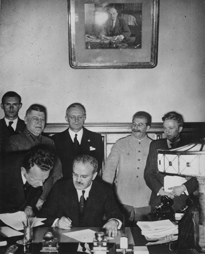 As Joseph Stalin and Joachim von Ribbentrop look on, Soviet Foreign Commissar Vyacheslav Molotov signs the Nazi-Soviet non-aggression pact, August 23, 1939
