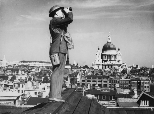 With St. Paul's Cathedral in the background, a spotter stands on a roof in London, searching for German aircraft