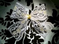 white bow with yellow thread and yellow ribbon