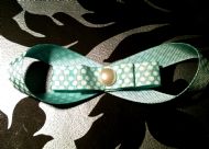 green bow with white polka dots and ivory bead