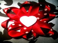 red bow with red ribbon and white polka dots and white heart centre