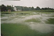 the original clubhouse and a flooded green