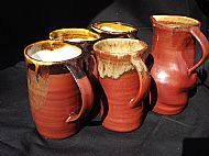 Four red coffee mugs and a jug